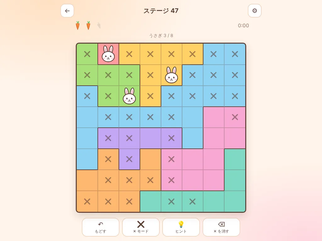 うさどくの画面。8×8 のマスが色のくぎりに分かれていて、白いうさぎが 3 わおかれ、おけないマスに ✕ がついている。上にはニンジンのライフが 2 本のこっている